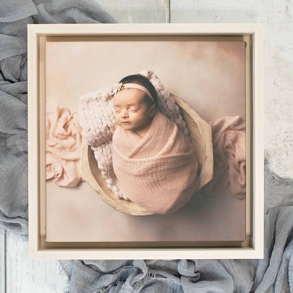 Framed fine art newborn canvas portrait displayed as heirloom wall art, showcasing custom artwork created by a Nashville newborn photographer.
