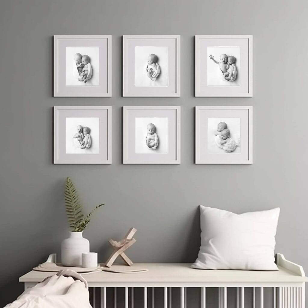 Custom gallery wall of framed newborn portraits displayed in a nursery, featuring heirloom artwork from a Nashville newborn photography session.