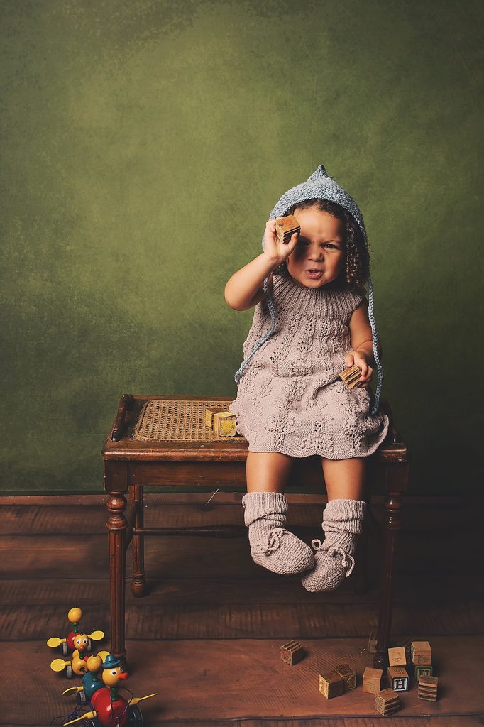 Child playing with vintage wooden blocks and toys during a creative Nashville child photography session.