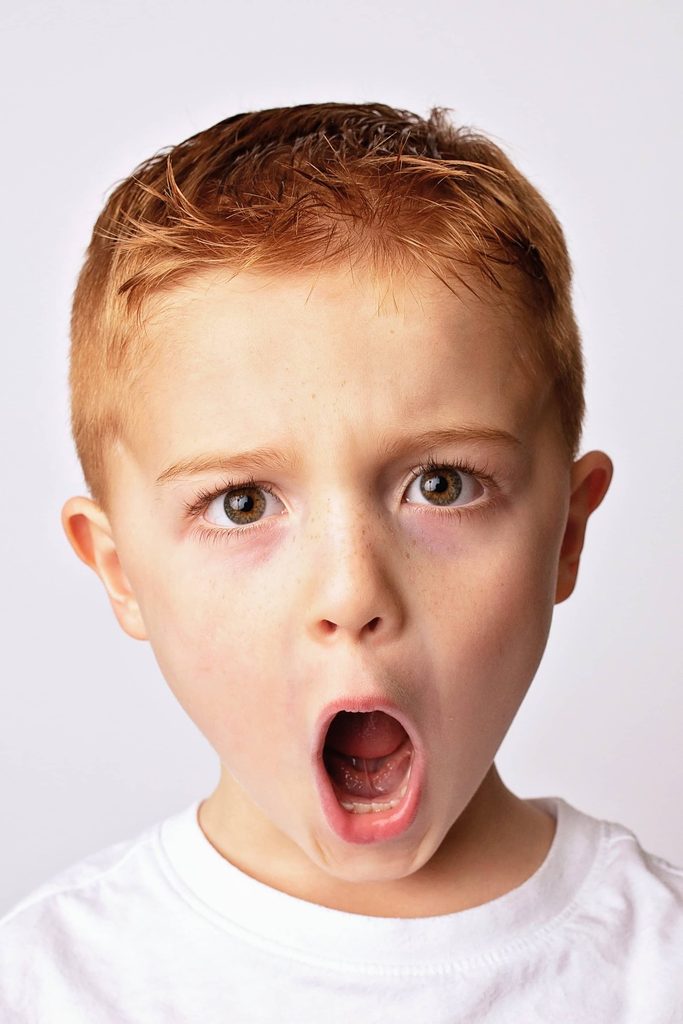 Close-up personality portrait of a young boy making a silly face during a Nashville child photography session.